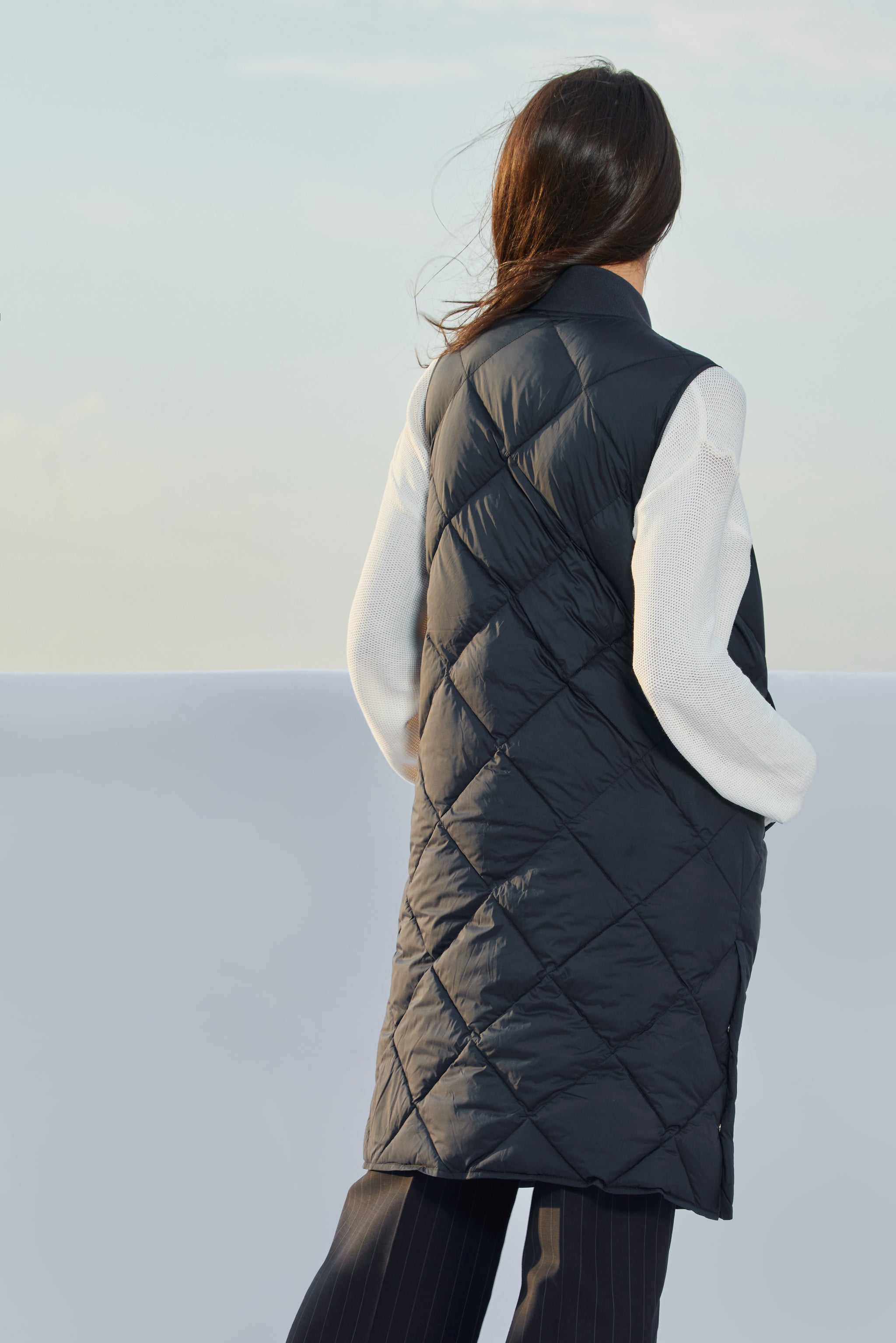 Vestă damă Madzerini dark navy, matlasată, fără mâneci, cu croială lungă și material lucios.